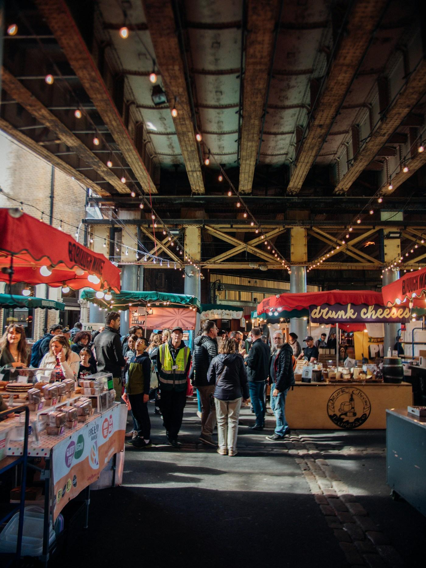 Visitors browsing stalls at a covered London food market