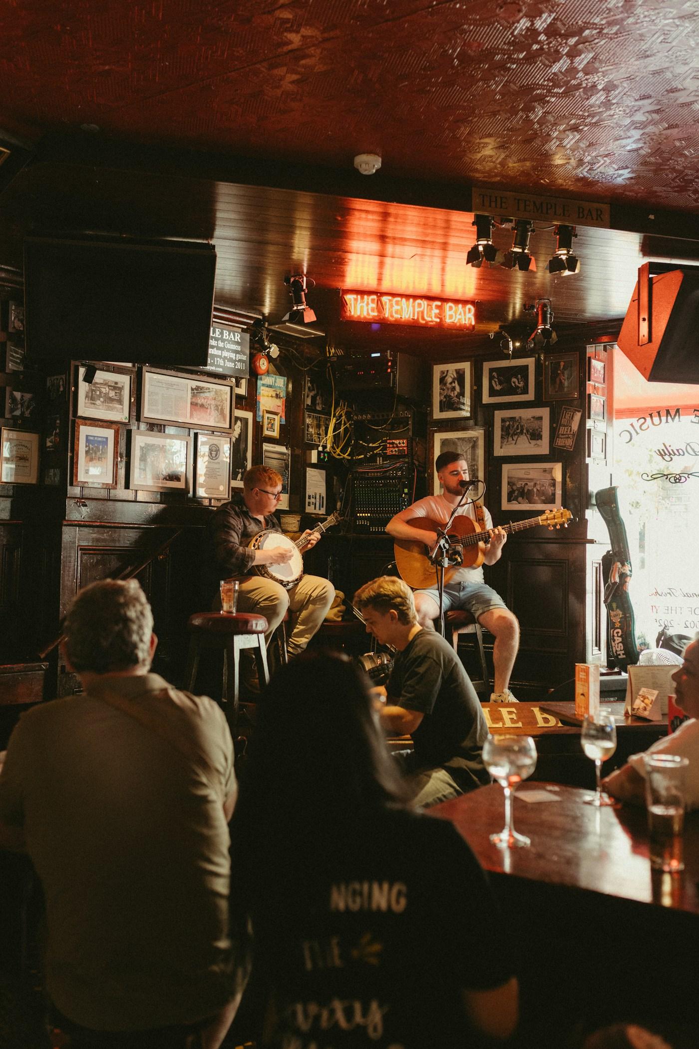 Two musicians playing banjo and guitar in a traditional pub